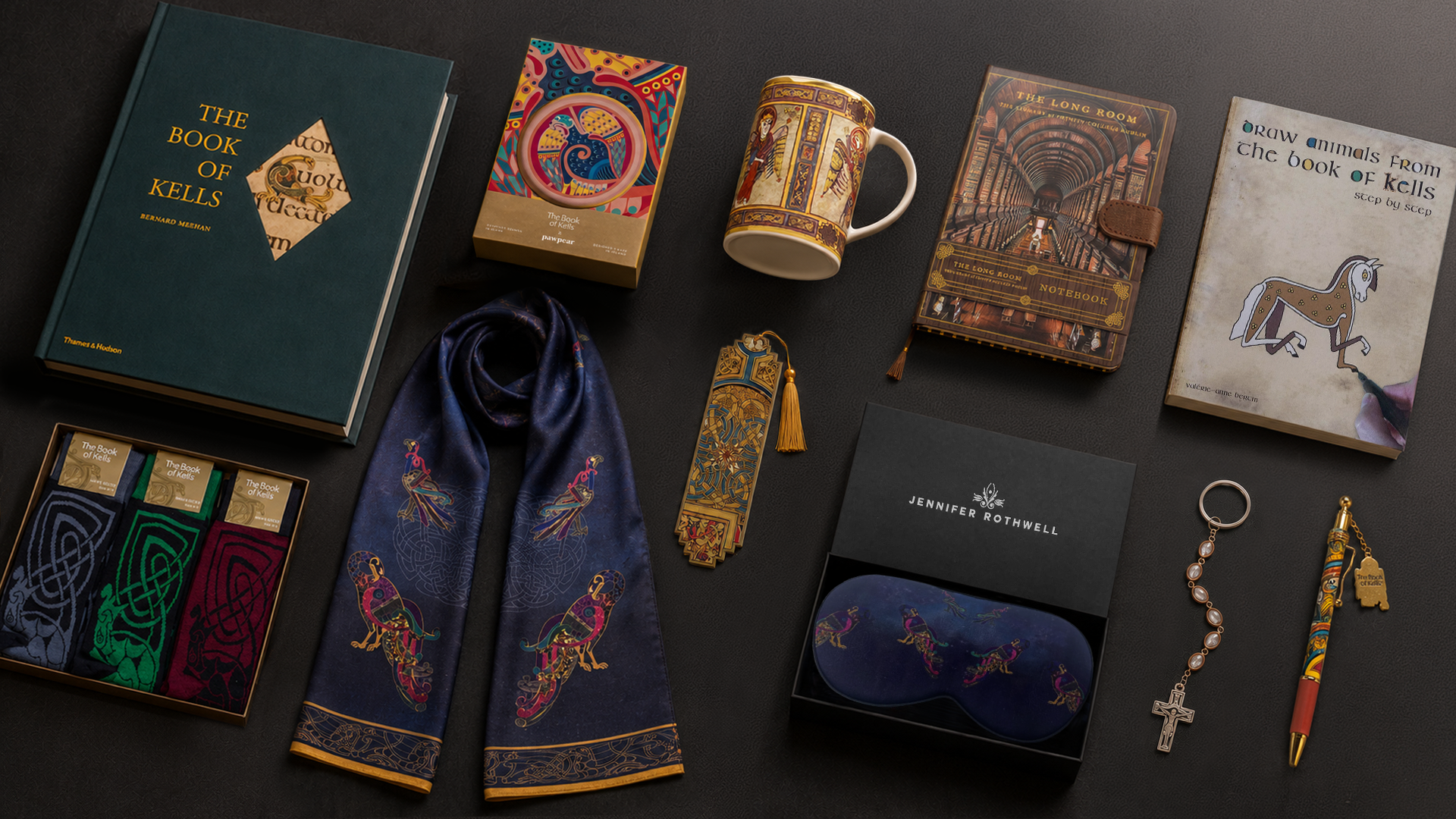 Collection of decorative books, a mug, a scarf, and other items on a dark surface