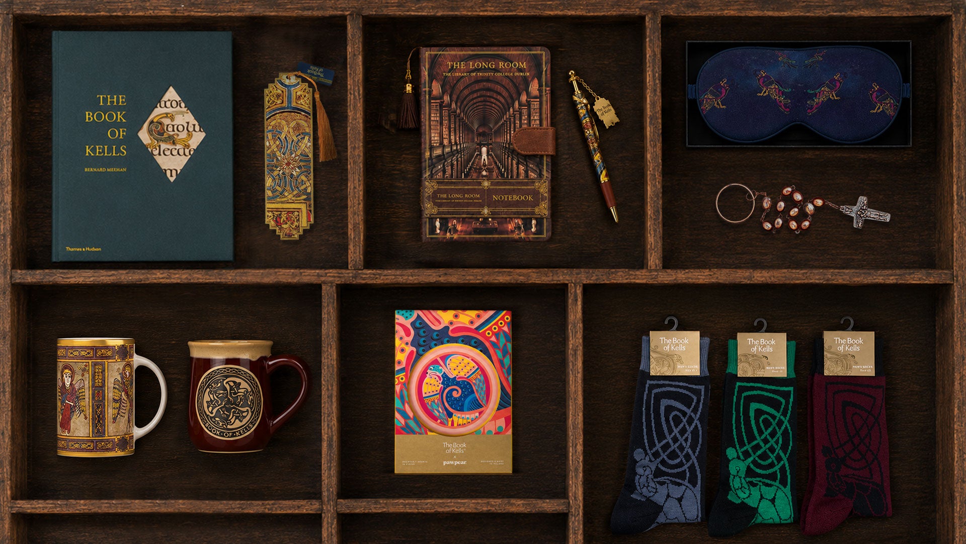 Collection of books, mugs, and decorative items inside a deep wooden drawer.